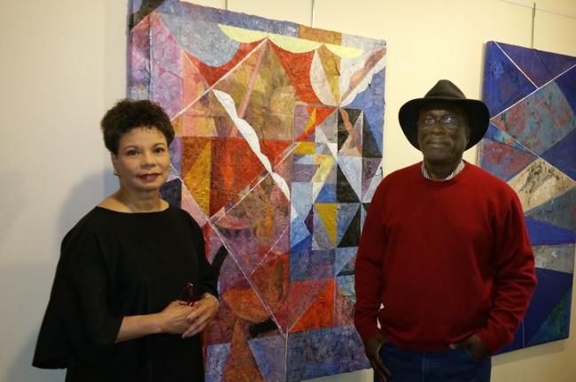 Dudley Charles with Maureen Bunyan standing beside another of his paintings